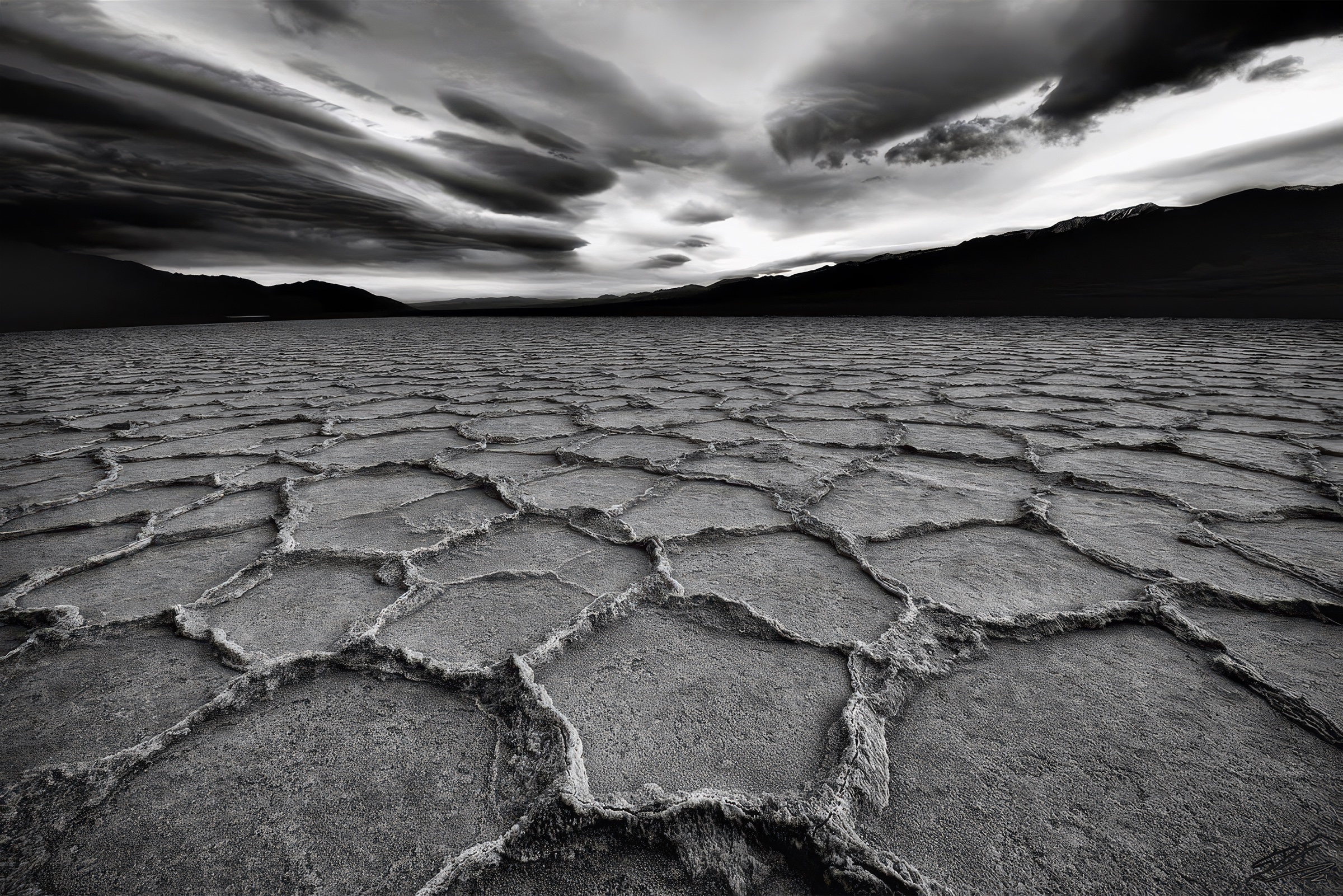 Black and white salt polygons stretching toward distant mountains